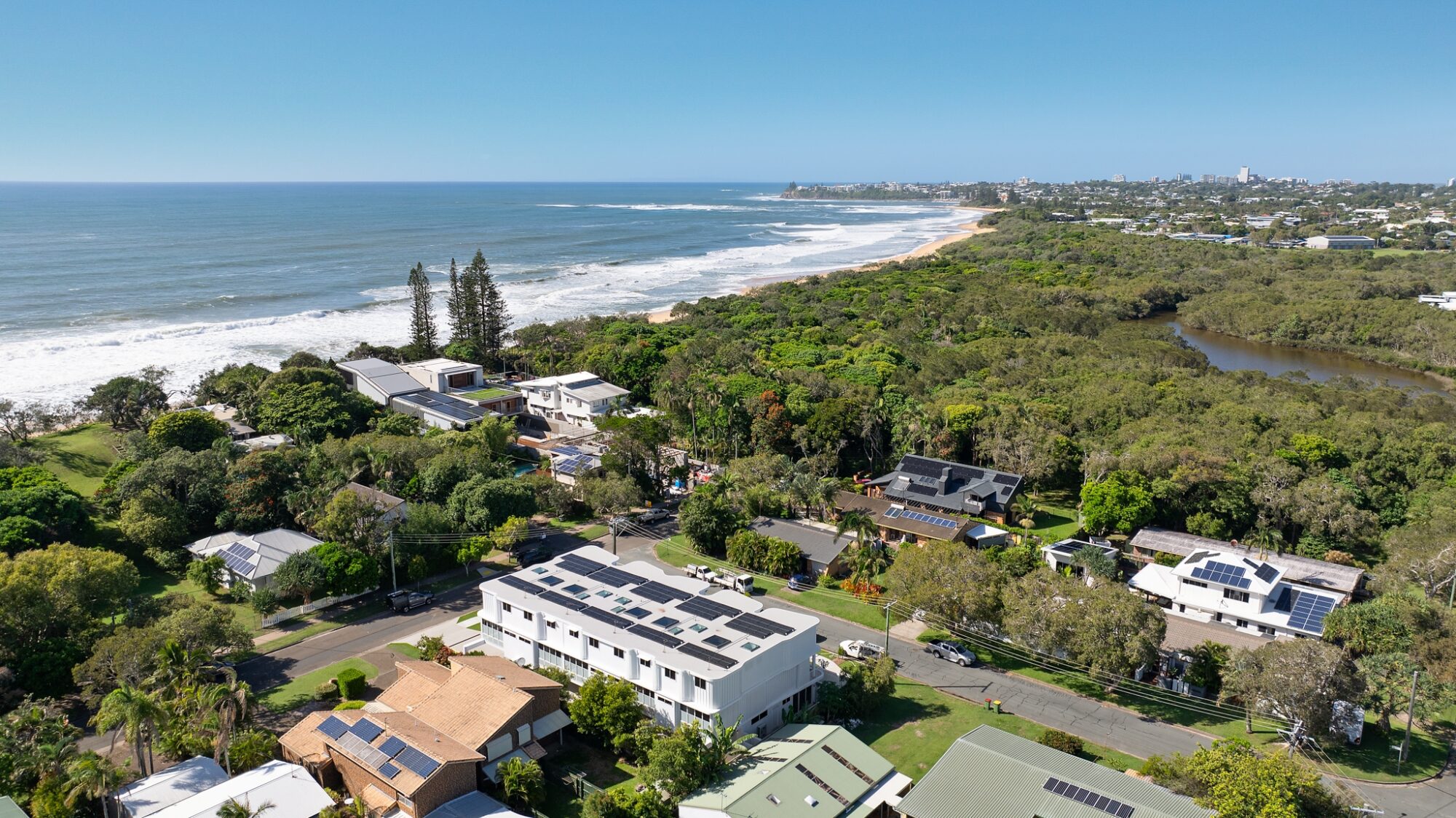Aerial view over Currimundi homes and bushland to the beach and Currimundi Lake